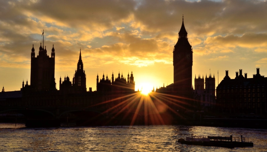 The Houses of Parliament, Westminster silhouetted by a sunburst from the setting sun.
