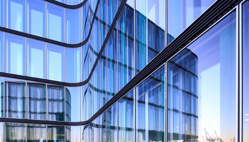 Reflection of the Hamburg harbor i a glass facade of a modern office building.